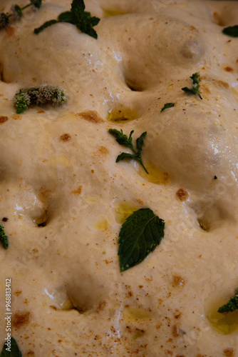 Focaccia bread close up on texture with fresh mint and sea salt flakes