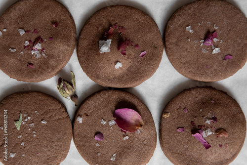 Round chocolate cookies with sea salt crystals and dried rose petals
