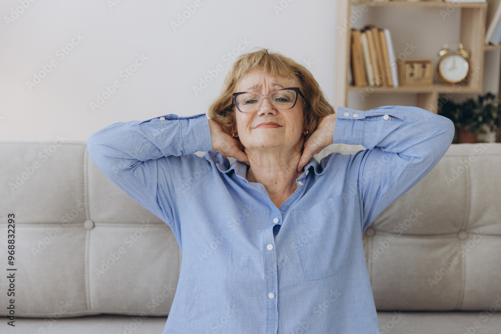 Sick senior adult elderly woman sitting on sofa touching the neck have shoulder and neck pain. Health care and medicine concept Sick senior adult elderly woman sitting on sofa touching the neck have shoulder and neck pain. Health care and medicine concept