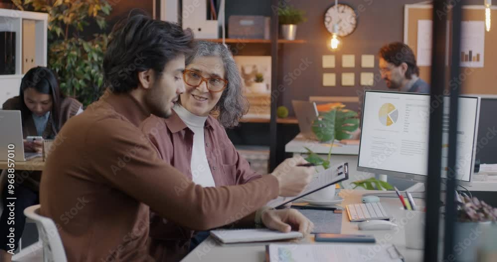 Man and woman colleagues talking and pointing at computer screen focused on business in office. Teamwork and cooperation concept. Man and woman colleagues talking and pointing at computer screen focused on business in office. Teamwork and cooperation concept.