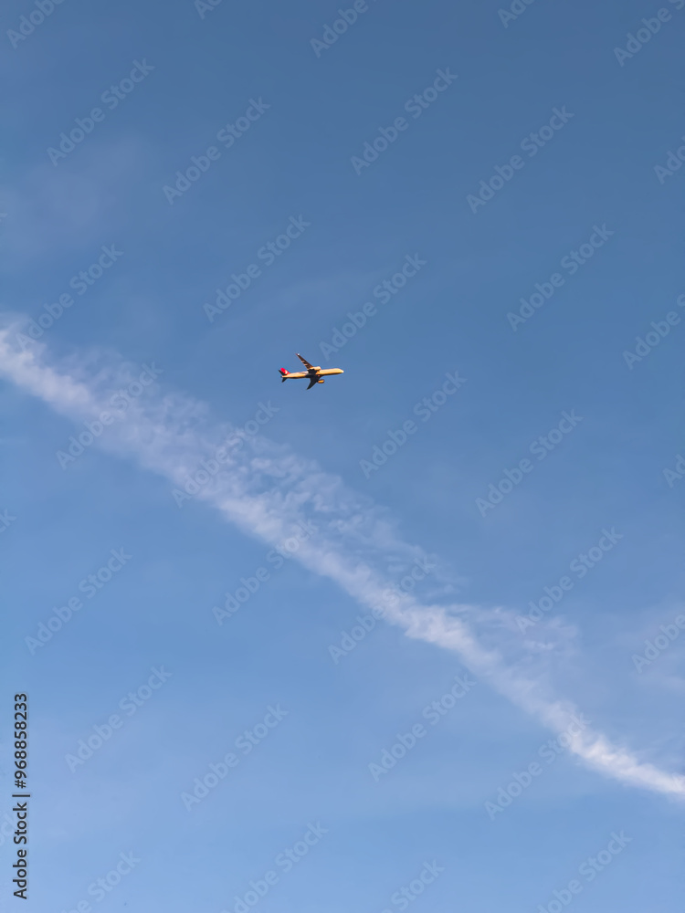 An airplane captured mid-flight against a clear blue sky, leaving a faint contrail behind, symbolizing travel and freedom. An airplane captured mid-flight against a clear blue sky, leaving a faint contrail behind, symbolizing travel and freedom.
