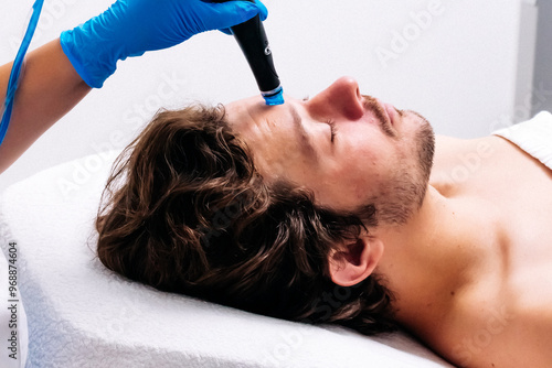 Man receiving a hydrafacial treatment in a modern cosmetic center. Innovative skin hydration and cleansing for visible rejuvenation. Perfect for promoting advanced skincare solutions.