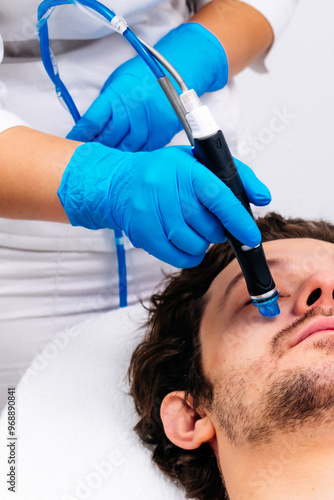 Man undergoing a facial peeling procedure in a beauty clinic, close-up. Rejuvenating hydro-air skin cleansing treatment. Perfect for promoting advanced skincare solutions.