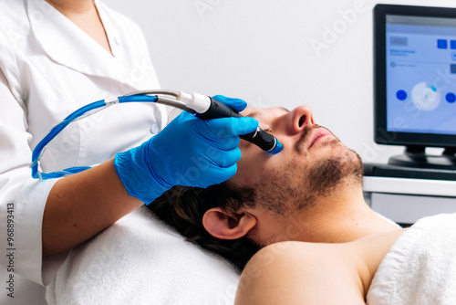 Man receiving a hydrafacial treatment in a modern cosmetic center. Innovative skin hydration and cleansing for visible rejuvenation. Perfect for promoting advanced skincare solutions.