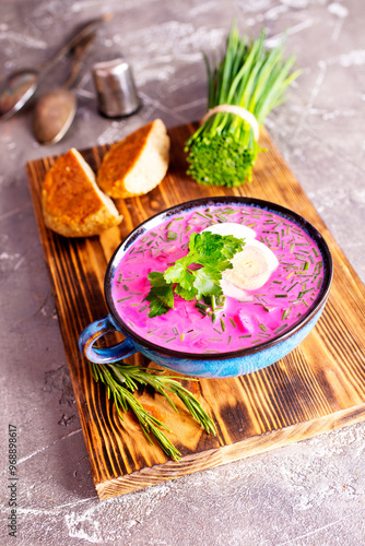 Traditional east european soup. Cold summer soup of beets, kefir, cucumbers, eggs and dill in a blue bowl closeup. photo