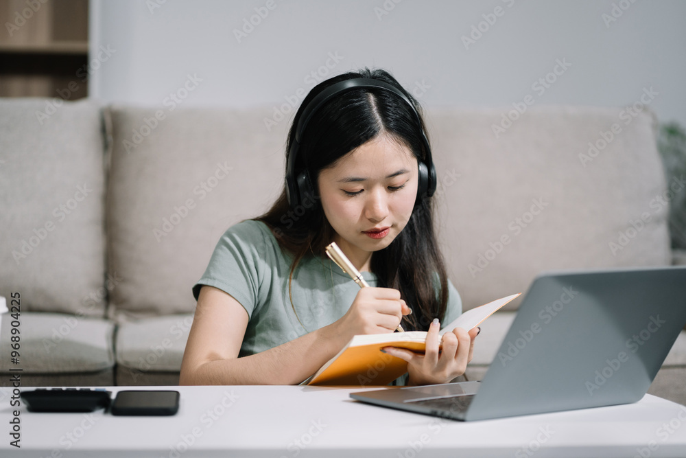 Smiling woman in headphones taking notes, motivated interested student studying online, using tablet, watching webinar training or listening to lecture, remote education concept. Smiling woman in headphones taking notes, motivated interested student studying online, using tablet, watching webinar training or listening to lecture, remote education concept.