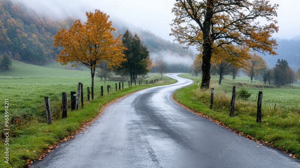 A charming curved road winds through fields with autumn foliage, misty hills in the distance, creating a tranquil and picturesque scene of the fall countryside. A charming curved road winds through fields with autumn foliage, misty hills in the distance, creating a tranquil and picturesque scene of the fall countryside.