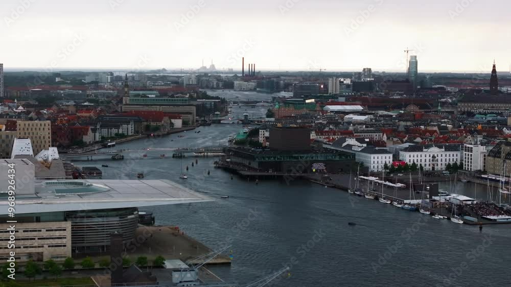 Aerial view of Copenhagen, Denmark featuring the city's canals, modern architecture, and historic buildings. Boats navigate the waterways Aerial view of Copenhagen, Denmark featuring the city's canals, modern architecture, and historic buildings. Boats navigate the waterways