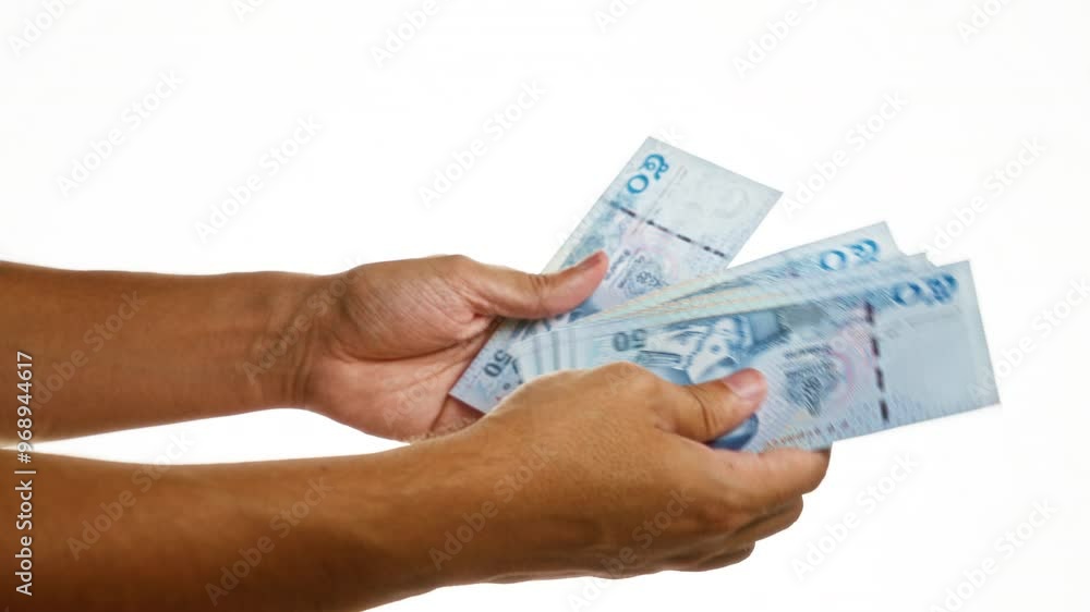 Hands holding thai baht notes over an isolated white background suggestive of financial transactions in thailand. Hands holding thai baht notes over an isolated white background suggestive of financial transactions in thailand.