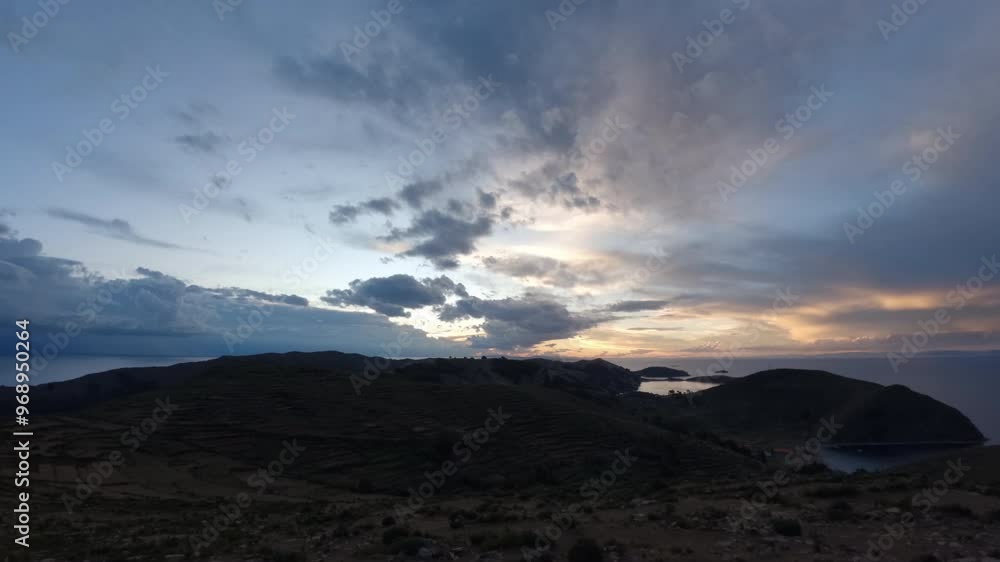 Timelapse of the sunset on Isla Del Sol Bolivia South America with clouds moving fast towards the camera and the sky becoming blue pink and purple with water and sea visible around the island Timelapse of the sunset on Isla Del Sol Bolivia South America with clouds moving fast towards the camera and the sky becoming blue pink and purple with water and sea visible around the island