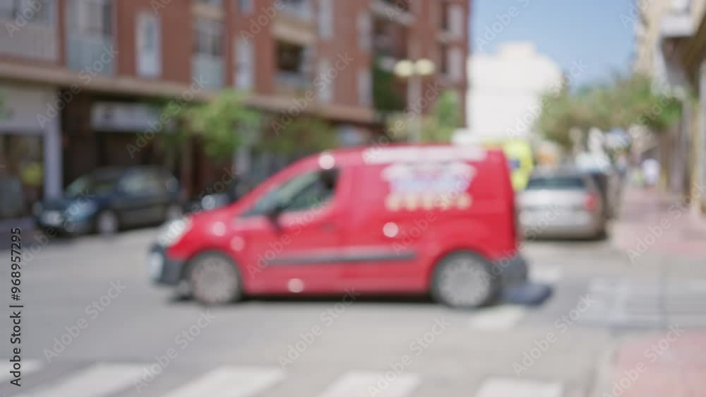 Out of focus city street scene with yellow ambulance in background featuring parked cars, blurred buildings and trees, during daytime Out of focus city street scene with yellow ambulance in background featuring parked cars, blurred buildings and trees, during daytime