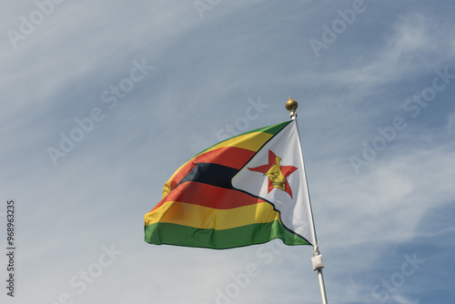 Flag of Zimbabwe, Zimbabwe, national symbol of Zimbabwe. Flag of Zimbabwe fluttering in blue sky. Independence Day. Flag of Zimbabwe, close-up. Great for news.