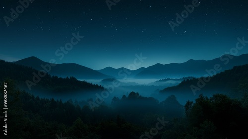 At night, fog covers mountains and forests in an expansive view evoking mystery and peace.