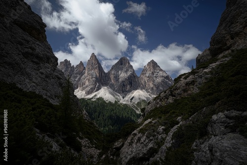 An idyllic scene with mountain peaks under cloudy skies near a coniferous forest surrounded by green conifers