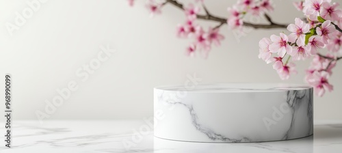 On a white background, a white marble podium holds a cosmetic display stand with blossom flowers. 3D rendering of the display stand.