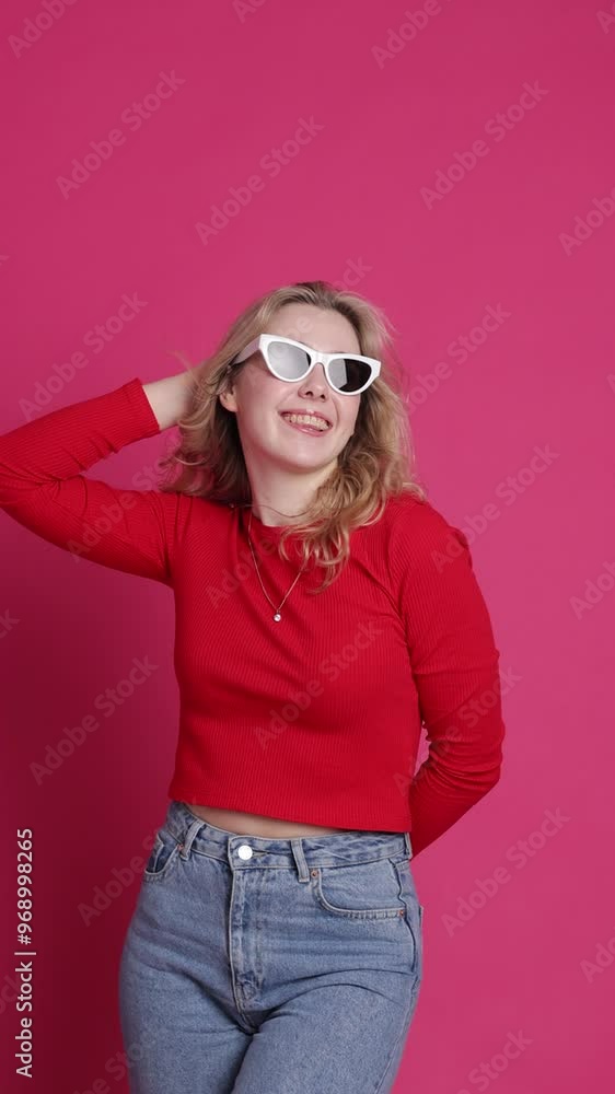 Cheerful young caucasian woman with transparent ceramic braces on teeth isolated on pink backdrop. Blond girl in eyeglasses looks at camera. Windy effect with fan. Beauty, health and fashion concept. Cheerful young caucasian woman with transparent ceramic braces on teeth isolated on pink backdrop. Blond girl in eyeglasses looks at camera. Windy effect with fan. Beauty, health and fashion concept.