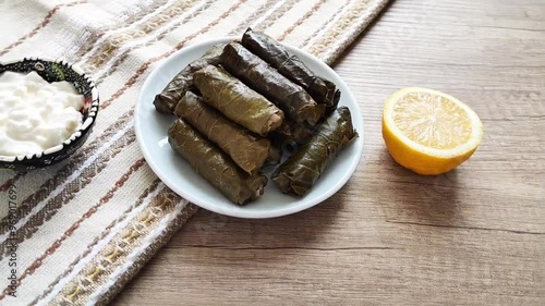 Delicious oriental Turkish dolma made of grape leaves stuffed with rice on a decorative plate