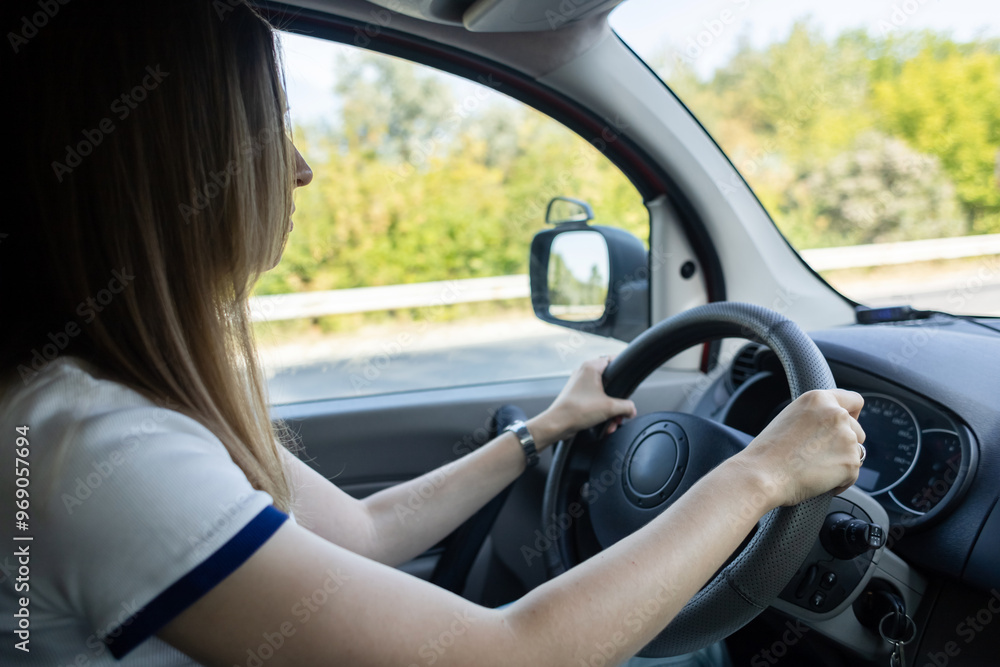 A woman drives a car and looks intently at the track. The navigator on the smartphone shows the map and the correct direction. Driving lessons on a manual transmission A woman drives a car and looks intently at the track. The navigator on the smartphone shows the map and the correct direction. Driving lessons on a manual transmission