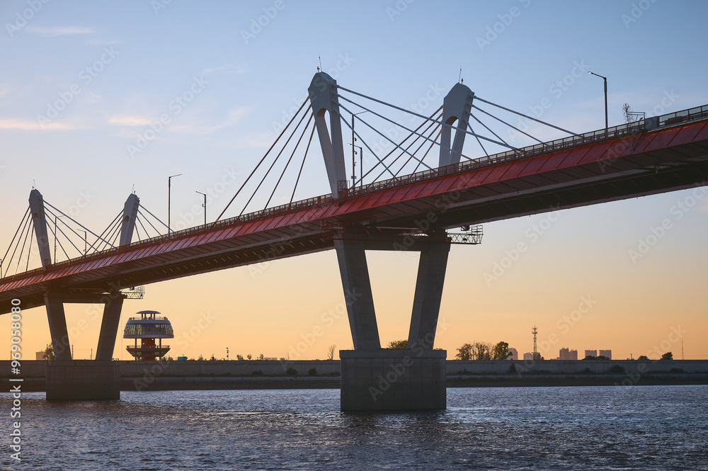 Cross-border bridge on the Amur River between Russia and China. View of the Chinese bank with a spherical observation tower on a summer evening at sunset. Cross-border bridge on the Amur River between Russia and China. View of the Chinese bank with a spherical observation tower on a summer evening at sunset.