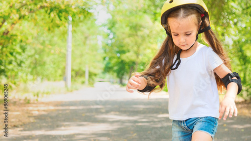 Girl skateboard with safety equipment - helmet, knee and elbow pads. Safe summer activity. Kids activity.