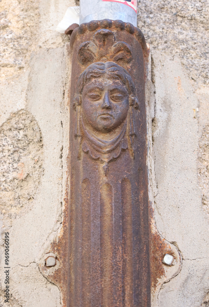 Naklejka premium Face on old forged metal gutter in Avila town