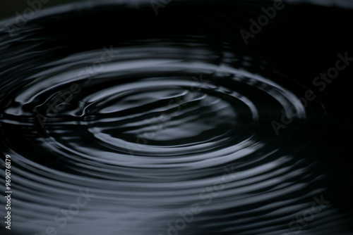 Ripple of water or water drop splash on black background. Abstract shape out of the water