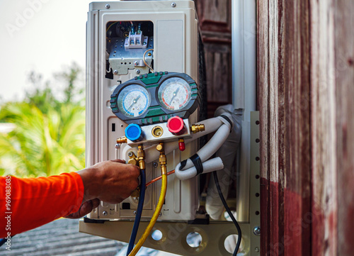 Air conditioning technicians install new compressor air  using monitor tool to check air conditioner system, Repairman HVAC system service technician using measuring manifold gauge checking  photo