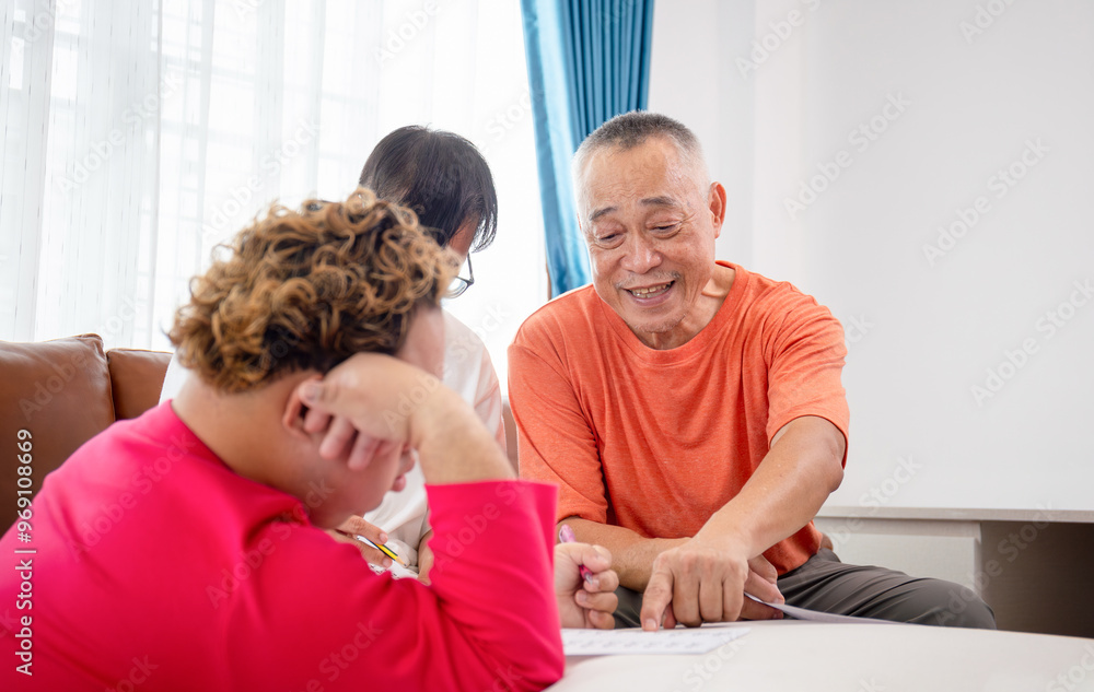 Senior man and grandchild practice math skill, interactive math game, Grandfather supervising grandchild sitting at sofa doing homework Senior man and grandchild practice math skill, interactive math game, Grandfather supervising grandchild sitting at sofa doing homework
