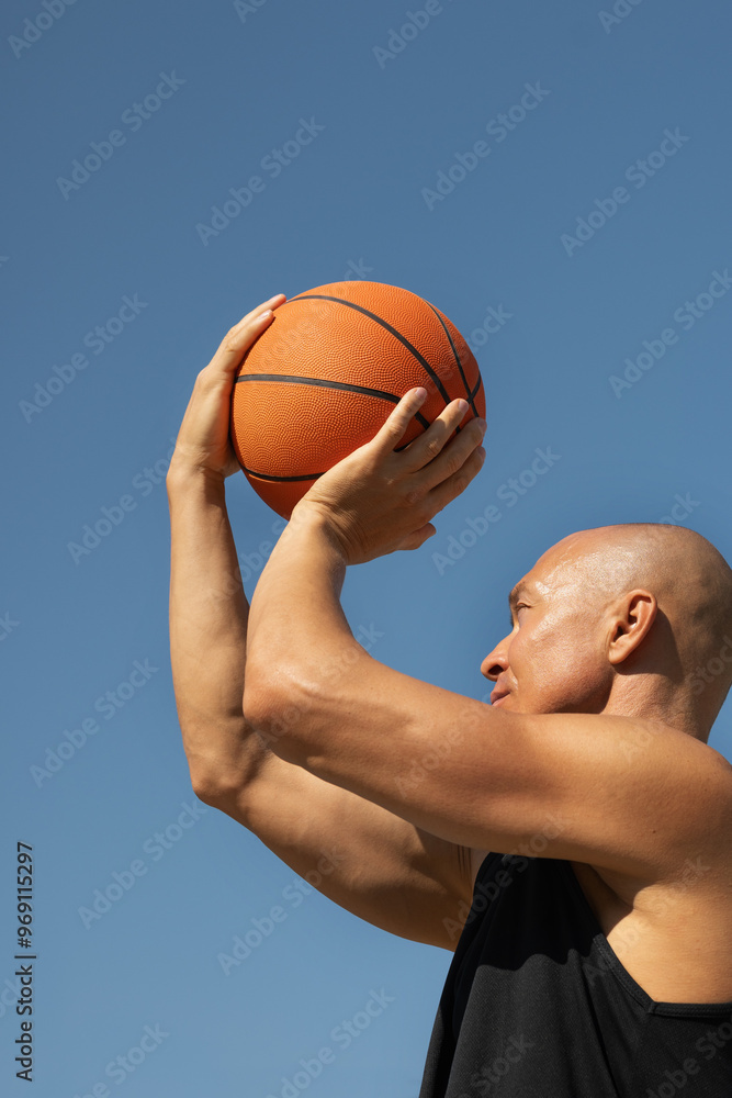 Basketball player or man tries to throw ball into basketball hoop on sports court. Game moment. Summer outdoors training. Basketball Throwing Technique. Basketball player or man tries to throw ball into basketball hoop on sports court. Game moment. Summer outdoors training. Basketball Throwing Technique.