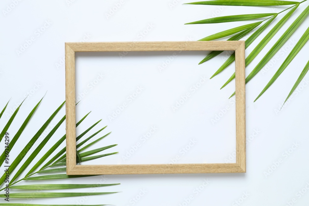 Green palm leaves with a wooden frame on a white background Green palm leaves with a wooden frame on a white background