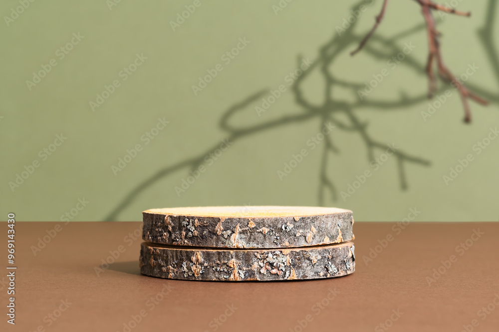 Wooden slice podium on a brown table on a green background with the shadow of tree branches. Premium empty scene for product promotion, beauty, natural eco cosmetic. Showcase, display case.