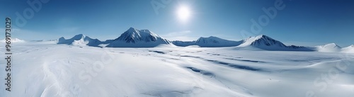 Panoramic view of a vast snowy mountain range under a clear blue sky, sun shining over the frozen arctic landscape 