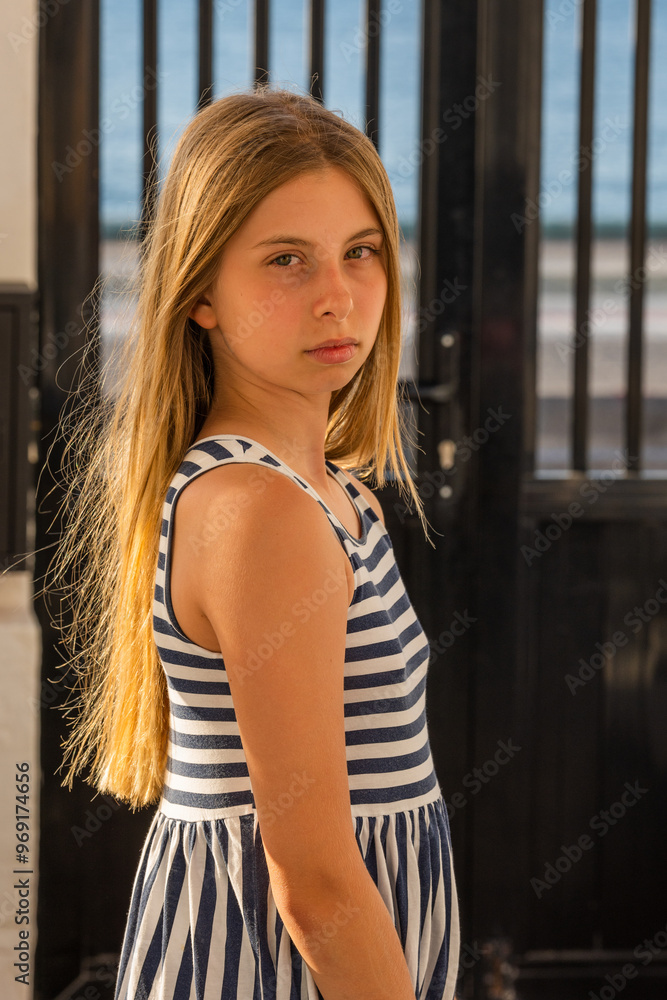 Cute Blonde Preteen in Blue and White Striped Dress, Sunlight Close-Up Portrait Cute Blonde Preteen in Blue and White Striped Dress, Sunlight Close-Up Portrait