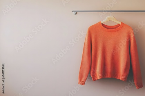 Orange shirt hanging on a clothes rack 
