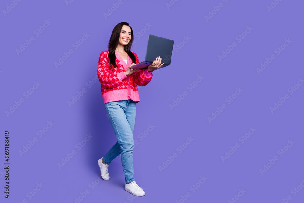 Full length photo of shiny attractive lady dressed pink cardigan chatting modern device walking empty space isolated violet color background Full length photo of shiny attractive lady dressed pink cardigan chatting modern device walking empty space isolated violet color background