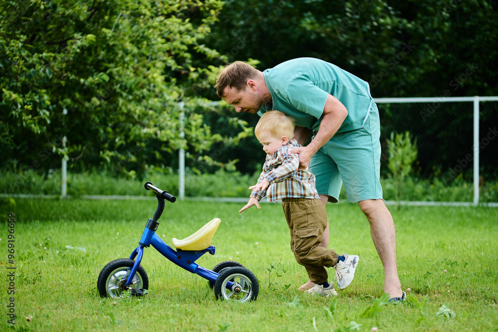 Happy family, father teaches little son to ride a bike Happy family, father teaches little son to ride a bike
