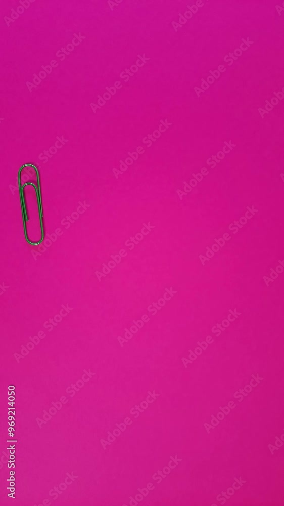 Paperclip moves from bottom to top of pink background. Vertical Stop motion animation with space to insert text, design, advertising. Back to school. Paperclip moves from bottom to top of pink background. Vertical Stop motion animation with space to insert text, design, advertising. Back to school.