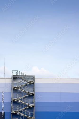 Obraz na płótnie External, evacuation staircase outside the industrial hall made of sandwich panels. Photo taken on a sunny day w salonie