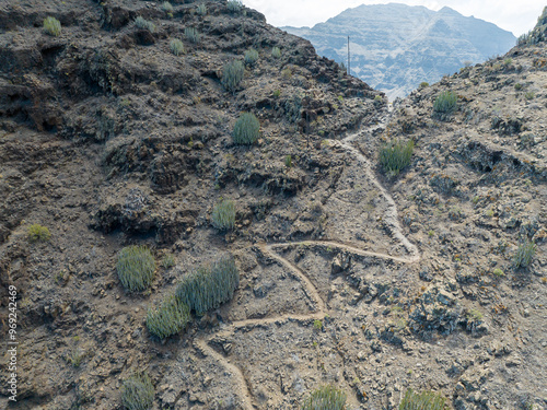 Aerial view of the trail through the mountains to Guigui beach, pristine black sand beach, Gran Canaria. Spain. Scenic trail photo