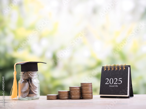 Wallpaper Mural 2025 desk calendar, Glass bottle with graduation hat and stack of coins. The concept of saving money for education, student loan, scholarship, tuition fees in year 2025 Torontodigital.ca