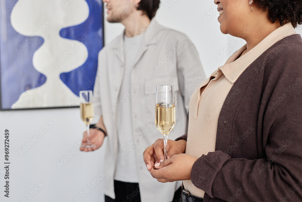 Cropped side view shot of two people holding champagne glasses and looking at paintings during art show opening ceremony, copy space Cropped side view shot of two people holding champagne glasses and looking at paintings during art show opening ceremony, copy space