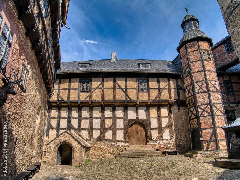 Historical half-timbered building with a stone courtyard, Falkenstein Castle in the Harz Mountains. Historical half-timbered building with a stone courtyard, Falkenstein Castle in the Harz Mountains.
