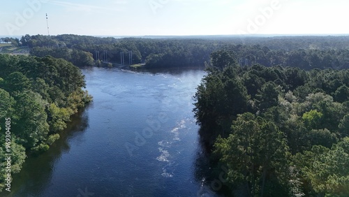 Aerial view of a river surrounded by green forest.