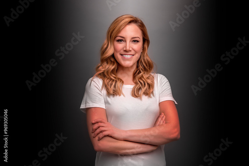 Attractive young woman in a T-shirt on a dark background.