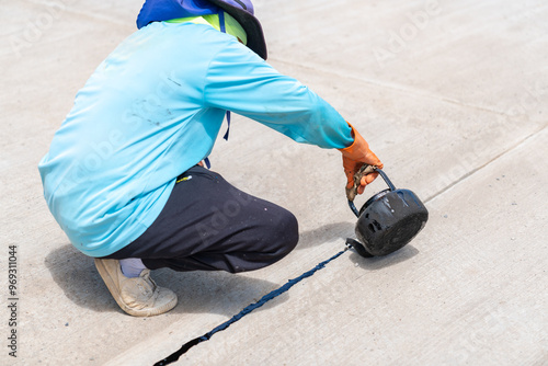 Sealing joint crack in asphalt road surface new work.
