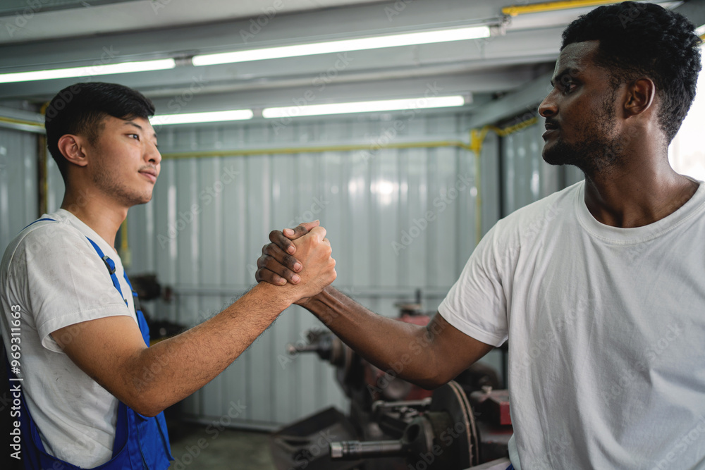 Two men shake hands in a workshop. Scene is friendly and professional. The idea is that the two men are working together and shaking hands to show respect and camaraderie Two men shake hands in a workshop. Scene is friendly and professional. The idea is that the two men are working together and shaking hands to show respect and camaraderie
