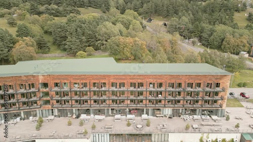 Stepantsminda, Georgia - 10th september, 2024: aerial panning view famous luxury Rooms Kazbegi hotel building with autumn caucasus mountains background photo