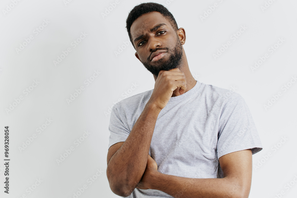 Pensive african american man contemplating with hand on chin, engaging eye contact with camera Pensive african american man contemplating with hand on chin, engaging eye contact with camera
