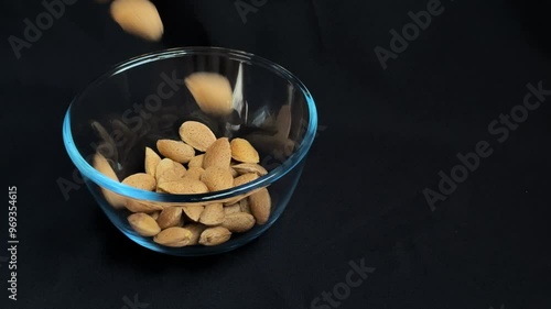 Almonds are poured into a glass bowl