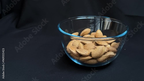 Almonds are poured into a glass bowl